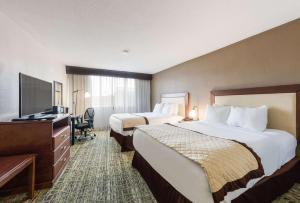 a hotel room with two beds and a flat screen tv at Clarion Hotel & Suites Mount Laurel in Mount Laurel