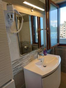 een badkamer met een witte wastafel en een spiegel bij Shardana in Quartu SantʼElena