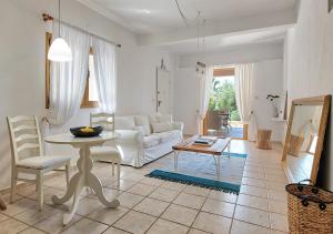 a living room with a white couch and a table at Sanidiamonds in Sani Beach