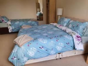 a bedroom with a bed with a blue comforter at Flat 1 Castlebank house Flats in Dingwall
