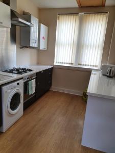 a kitchen with a stove and a washing machine at Flat 1 Castlebank house Flats in Dingwall