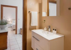 a bathroom with a white sink and a mirror at Sanidiamonds in Sani Beach