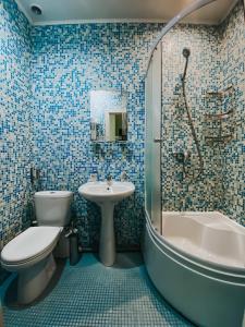 a blue tiled bathroom with a toilet and a sink at Минима Китай-Город in Moscow
