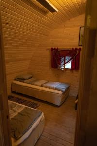 Habitación de madera con 2 camas y ventana en Soesauna Farmstay, en Vetla