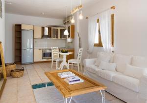 a living room with a white couch and a table at Sanidiamonds in Sani Beach