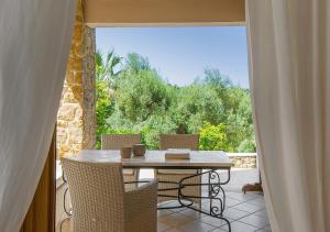a patio with a table and chairs on a balcony at Sanidiamonds in Sani Beach