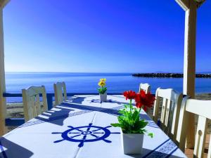 einen Tisch mit Blumen auf dem Strand in der Unterkunft Medusa Apartments in Kateliós