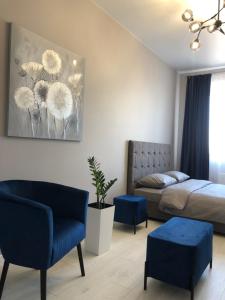 1 dormitorio con 1 cama y sillas azules en Люкс апартаменти в центрі Жк Театральний, en Rivne