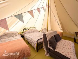a tent with two beds and a couch in it at Abercefel Retreat in Llandysul