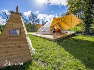 Abercefel Retreat في Llandysul: خيمة كبيرة وبيت كلب على العشب