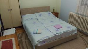 a bed in a bedroom with purple sheets and books at Prenoćište Dika in Višegrad