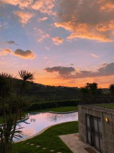 una puesta de sol sobre una piscina en un patio en quarto familiar zona guimaraes en Guimarães