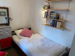 ein kleines Schlafzimmer mit einem Bett mit einem Kissen darauf in der Unterkunft Ferienhaus Frieda - mit Balkon, Garten und Terrasse in Nürnberg