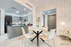 a dining room and kitchen with a table and chairs at Stylish 2BR in Bella Rose Al Barsha South by Deluxe Holiday Homes in Dubai