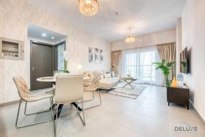 a living room with a table and a couch at Stylish 2BR in Bella Rose Al Barsha South by Deluxe Holiday Homes in Dubai