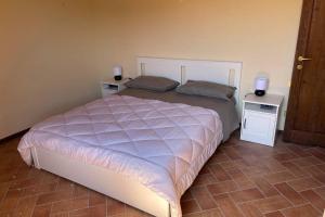 um quarto com uma cama grande e 2 mesas de cabeceira em Casa Vacanze nel cuore della Toscana em Castagno