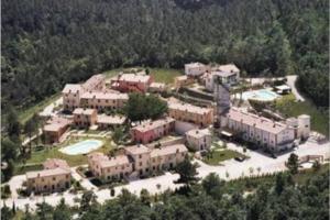 vista aerea di un grande edificio con piscina di Casa Vacanze nel cuore della Toscana a Castagno