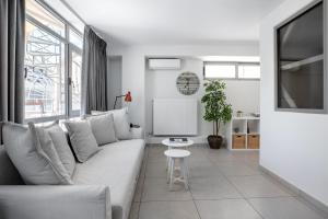 ein weißes Wohnzimmer mit einem weißen Sofa und einem Tisch in der Unterkunft Supreme D1 Penthouse 131m² in Syntagma in Athen