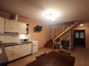 a kitchen with a kitchen table and a stairway at NA GWiZDÓWCE DOM 35, ZAŁAKOWO, KASZUBY in Załakowo