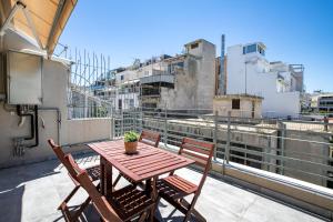 Una mesa y sillas de madera en un balcón. en Supreme D1 Penthouse 131m² in Syntagma, en Atenas