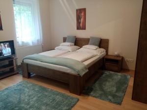 a large bed in a room with a television at Hévíz Lake Apartman in Hévíz