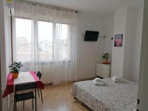 a bedroom with two beds and a table and a window at Casa Doina Airport in Pisa
