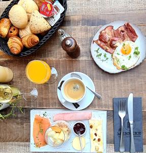 a table topped with plates of breakfast food and a cup of coffee at Hotel Het Menneke in Hasselt