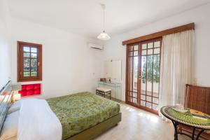 Schlafzimmer mit einem Bett und einem Tisch in der Unterkunft Emerald Dawn Villa in Pefki Rhodes