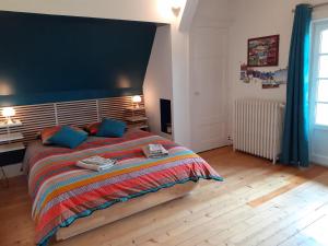 een slaapkamer met een groot bed met een blauwe muur bij La Fée des Eaux in Vernaison