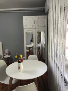 ein weißer Tisch und Stühle mit einer Blumenvase drauf in der Unterkunft Apartman studio Pavle i Petra in Sremski Karlovci