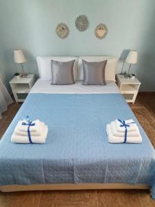 a bedroom with a blue bed with towels on it at Giardino di Circe in Agrigento +50 photos