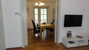 a dining room with a table and a television on a wall at FeWo Obstfelderschmiede in Mellenbach-Glasbach