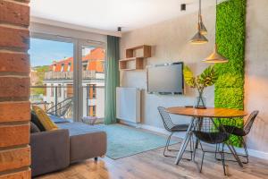a living room with a table and a couch at Apartamenty Homely Place 1 - Parking in Poznań