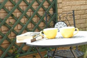 dos tazas de café y un libro sobre una mesa en Linden Gap Guesthouse, en Johannesburgo