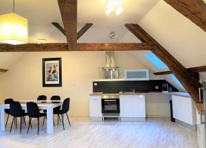 eine Küche und ein Esszimmer mit einem Tisch und Stühlen in der Unterkunft Résidence Investar appartement 5 in Montluçon