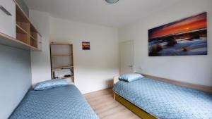 格羅爾斯泰恩的住宿－Dolce Vita Gerolstein - Luca，卧室内的两张床,墙上有绘画作品