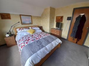 - une chambre avec un grand lit et une couverture rouge et grise dans l'établissement Comfort House, à Havant