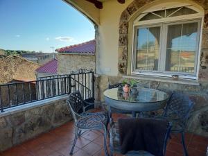 un patio con tavolo e sedie su un balcone di Casa de turismo rural - Mirador de Santa Marina a Sobradillo