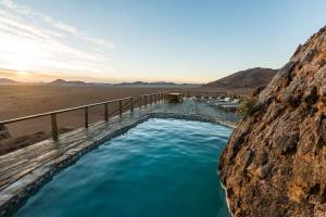 a hot tub in a mountain with blue water at Elegant Desert Camp in Sesriem
