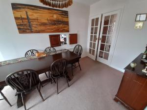 een eetkamer met een houten tafel en stoelen bij Comfort House in Havant