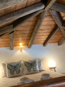 Schlafzimmer mit Holzdecken und einem Bett mit Schmetterlingskissen in der Unterkunft Althea Garden House in Hydra