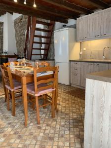 a kitchen with a table and chairs and a refrigerator at Althea Garden House in Hydra +18 photos