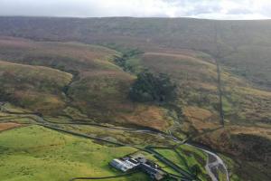 an aerial view of a winding road in a field at Kingsdale Head Cottage in Weathercote