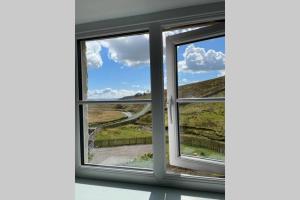 an open window with a view of a road at Kingsdale Head Cottage in Weathercote