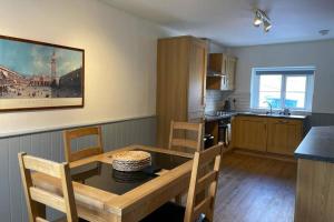 Kingsdale Head Cottage في Weathercote: مطبخ مع طاولة وغرفة طعام