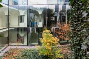 a glass building with a garden in front of it at Address Deluxe Downtown in Ljubljana