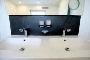 a bathroom with a white sink and a mirror at Marias Guest House in Eynatten