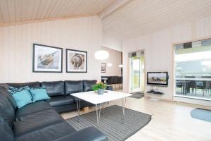 - un salon avec un canapé noir et une table dans l'établissement Resort 1 Surfer's Residence E 137, à Großenbrode