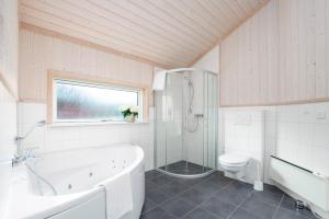 un bagno bianco con vasca e WC di Resort 1 Surfer's Residence E 137 a Grossenbrode Altre 15 foto