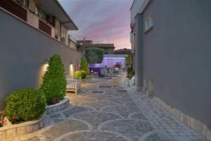 a stone walkway with plants and chairs in a courtyard at Rome Airport Inn in Fiumicino